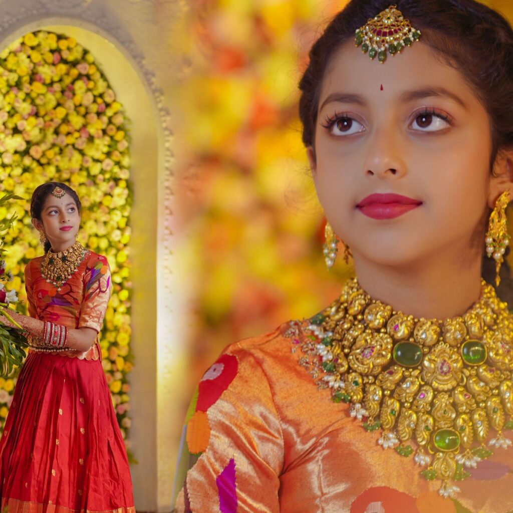 Ranhitha and Sanhitha elegantly dressed in half-sarees during the main ceremony, surrounded by family blessings.